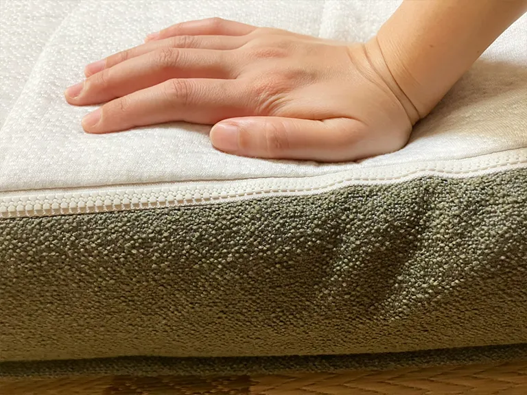 CUSHY+のマットレストッパーの硬さを手で確認する様子